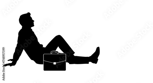 A silhouetted businessman relaxes with a briefcase nearby appearing contemplative