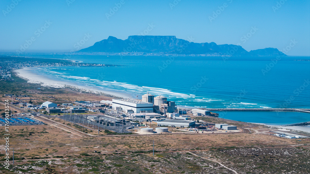 Fototapeta premium Aerial view of the Koeberg nuclear power station near Cape Town, on the Cape west coast. The power station has been operational without incident since the eighties. Table Mountain in background.