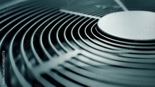 Close-up of a black metal fan grill with concentric circular patterns.