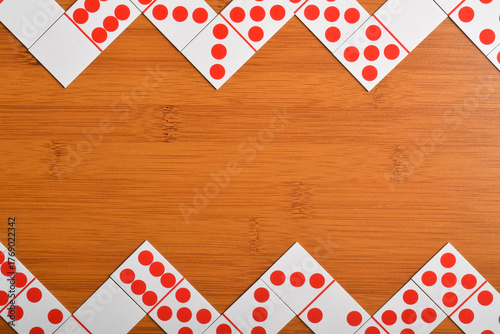 Domino pieces on a brown wooden table with copy space