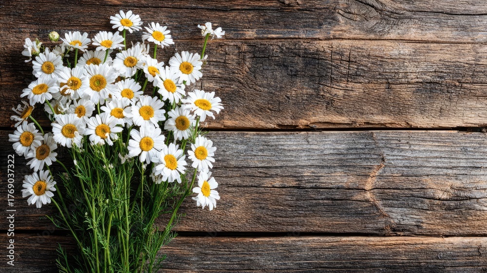 Obraz premium Wildflowers and wooden table background created concept. A beautiful bouquet of daisies on a rustic wooden background.