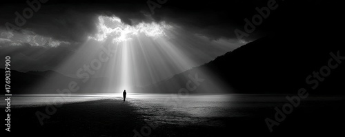 A man walking through a dark valley toward the heavenly concept. A solitary figure stands in a dramatic landscape of light and shadow.