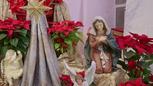 Catholic nativity scene with virgin Mary. Christmas religious still life with red flowers prayer and faith detail closeup