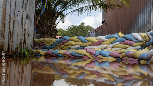 Many sandbags are stacked and reflected in the water.