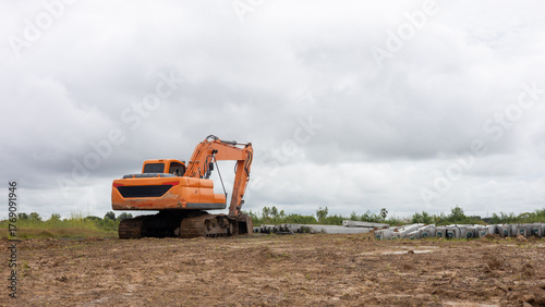 Low angle view of yellow backhoe on the ground near a concrete pillar.