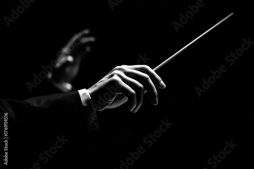 Hands of a conductor against a dark backdrop