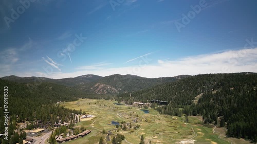 Stunning aerial drone view of Olympic Valley in Lake Tahoe region. Mountain landscape showcases ski resort and alpine scenery. Perfect for California travel and winter sports.