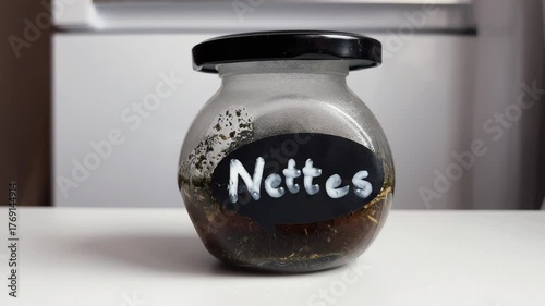 An infusion of nettle leaves in a glass jar placed on the table. Preparation natural medicine for the treatment of various diseases and hair loss.