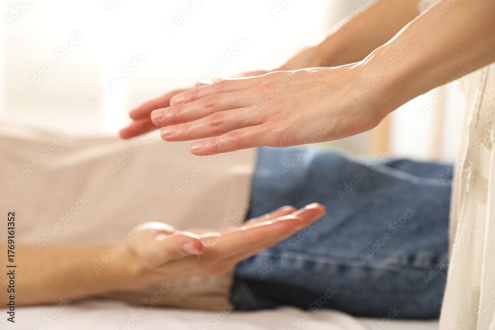 Obraz premium Reiki master healing patient's aura during therapy indoors, closeup