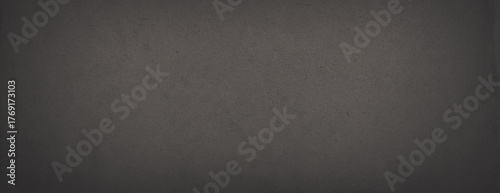 Dark wide panoramic background. Old fade paper texture. Dark panorama with empty space. Rough faded surface. Spots and grain. Blank vintage background for design. Shaded retro texture with vignette.