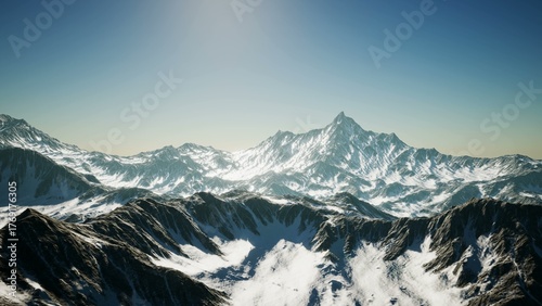 Fotografie Breathtaking snow covered peaks rise dramatically against a vivid blue sky, illuminated by the warm glow of the sun setting over the mountainous landscape