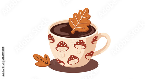 A cozy autumn beverage in a charming mushroom-patterned mug, featuring a gingerbread leaf cookie and a fallen leaf.