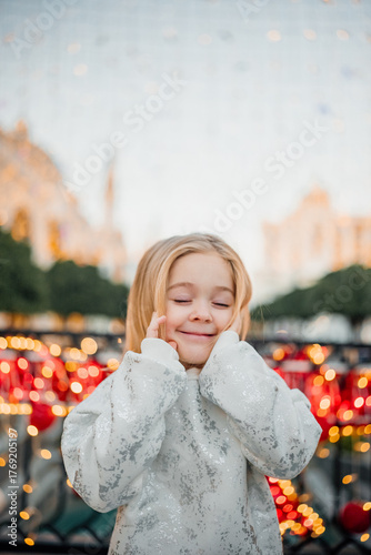 Joyful child enjoying festive lights at a holiday celebration in the city square