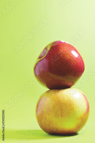 Stacked apple, various colors on a green background.