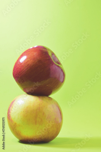 Close up, stacked apple, various colors on a green background.	