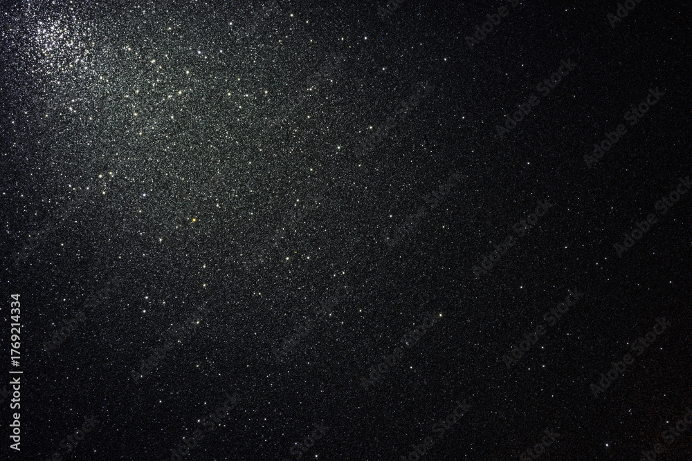 Fototapeta premium Black glitter texture with asphalt like relief and scattered sparkles, illuminated from upper left corner