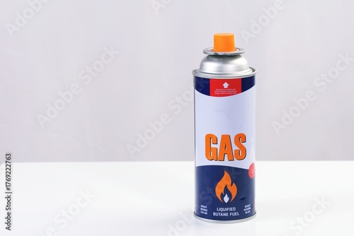 Small portable gas canister with safety valve, used for torch, camping stove, or culinary purposes, isolated on white background.
