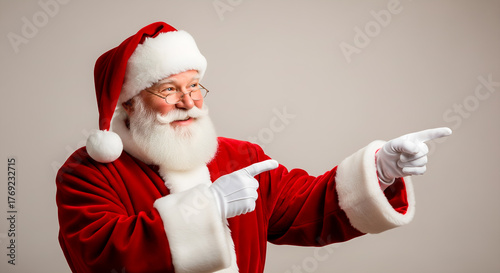 Santa Claus pointing to the right, smiling and looking festive