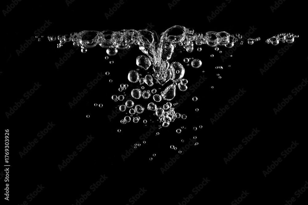 Obraz premium Clear water bubbles rising in black background, creating clean and refreshing,symbolizing purity, freshness, oxygen, and natural element concept for design, advertising, or background use.
