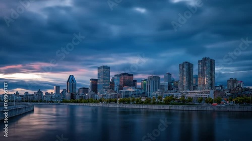 Wallpaper Mural A stunning panoramic view of a vibrant city skyline at sunset, reflecting on the water, with dramatic clouds overhead, showcasing urban architecture and serene waterfront Torontodigital.ca