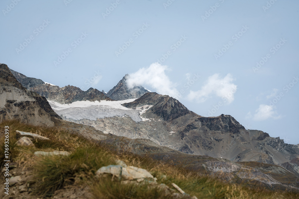 Fototapeta premium Hiking in the Swiss Alps with beautiful mountains in the background.