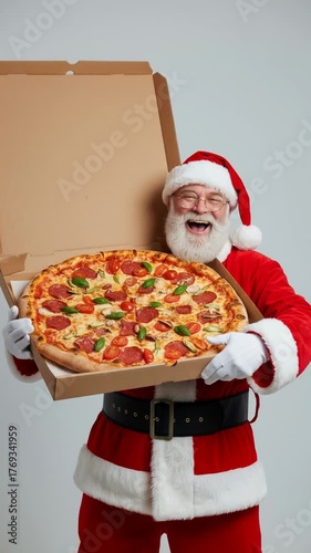 jovial Caucasian Santa Claus presents pizza with pepperoni and cheese, smiling against light gray background, evoking joyful winter celebration, Christmas, festive spirit, food, happiness