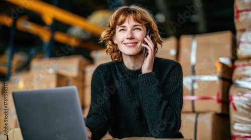 Woman sits in warehouse talks on cell phone she converses on phone seated within expansive warehouse