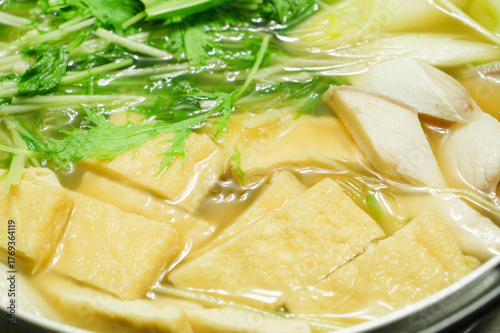 A stewed hot pot dish featuring mizuna greens, green onions, mackerel, and fried tofu—a Japanese winter delicacy.