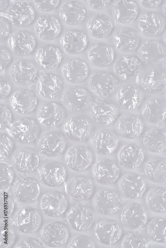A vertical, full-frame macro shot of clear plastic bubble wrap, creating a repetitive texture of inflated air pockets