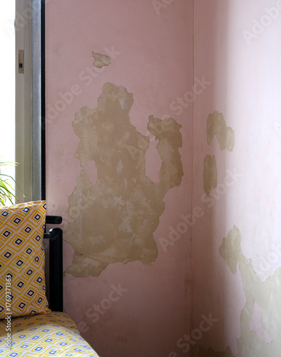 Closeup of a wall with damage due to paint flaking off because of dampness and moisture