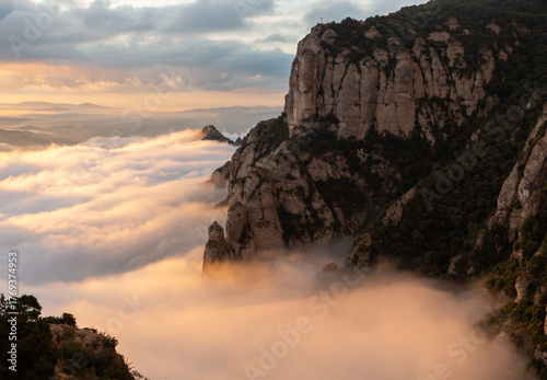 Sea of ​​clouds at sunrise with a mountain cliff