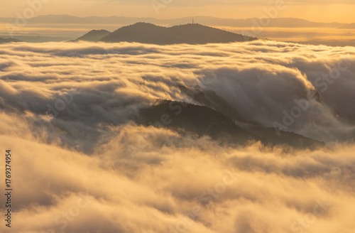 Sea of ​​clouds at sunrise with mountains in the center and background