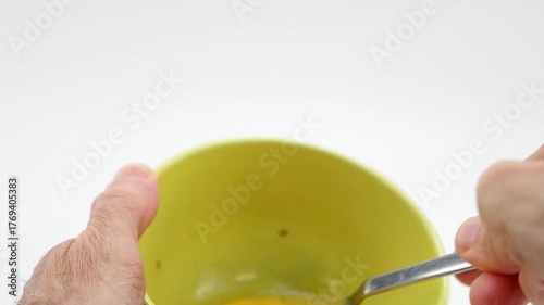 Dettaglio mani che sbattono con una forchetta tuorlo e albume di uova per una frittata, sfondo bianco