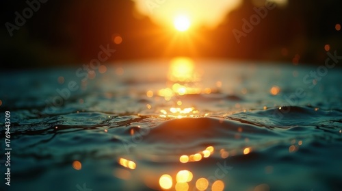 Golden sunset reflected on rippling water surface with splashes