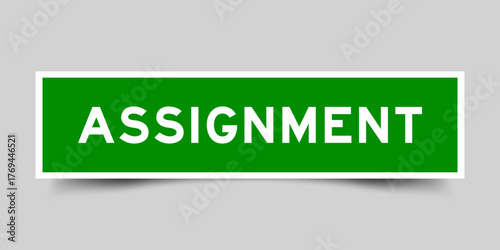 Green color square shape sticker label with word assignment on gray background