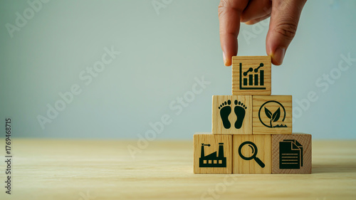 Hand Stacking Wooden Blocks with Icons Representing Sustainability and Business Growth strategy