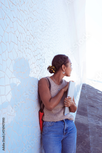 Young woman learning outdoors holding laptop