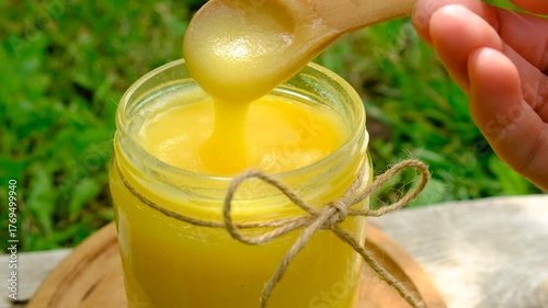 Ghee in a jar in a meadow. Selective focus.