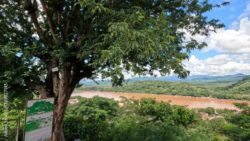 Aerial view from Mount Phousi overlooking Luang Prabang, northen Laos - spring day with sunshine and clouds over the Mekong River and city landscape.