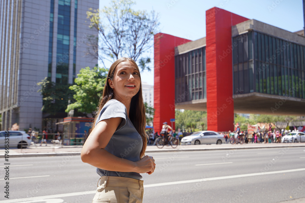 Fototapeta premium Brazilian young woman walking on Paulista Avenue in Sao Paulo, Brazil