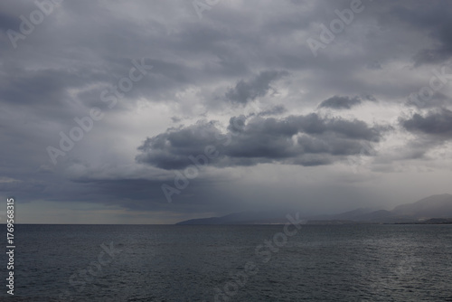 Raining sky over Aegean Sea, Crete. Minimalism. Misty morning in the sea. Calm view. Tranquil empty landscape with soft blue gray sky. Natural gloomy weather.