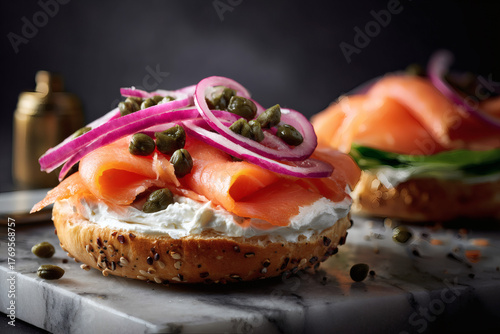 classic lox bagel with silky smoked salmon red onion capers cucumber and dill over cream cheese on a seeded roll shot in dramatic light