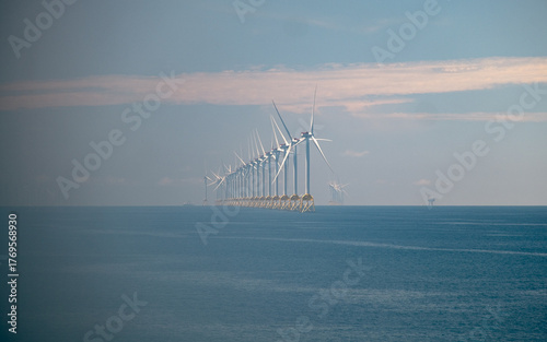 Fotografia Long line of offshore wind turbines extending from right to left in the open sea