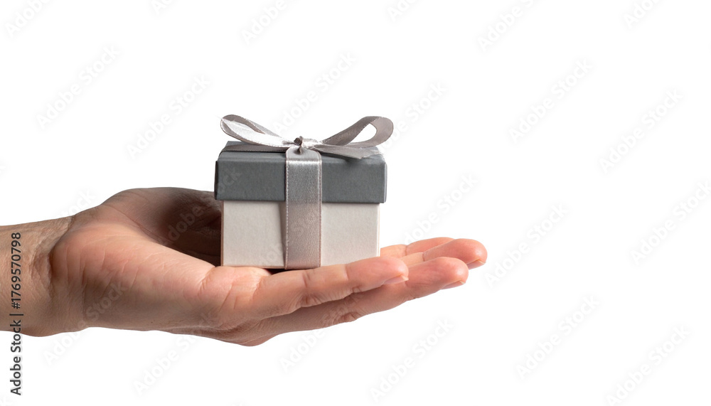 Obraz premium A hand holds a beautifully wrapped gift box with a ribbon on top. The box is presented, conveying the act of giving. 