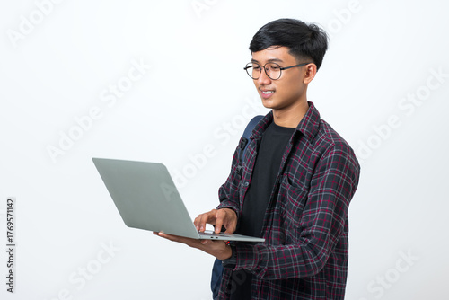 Smiling college student using laptop on white background