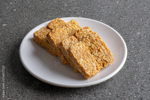 Crispy and tasty fried tempeh served on a white plate