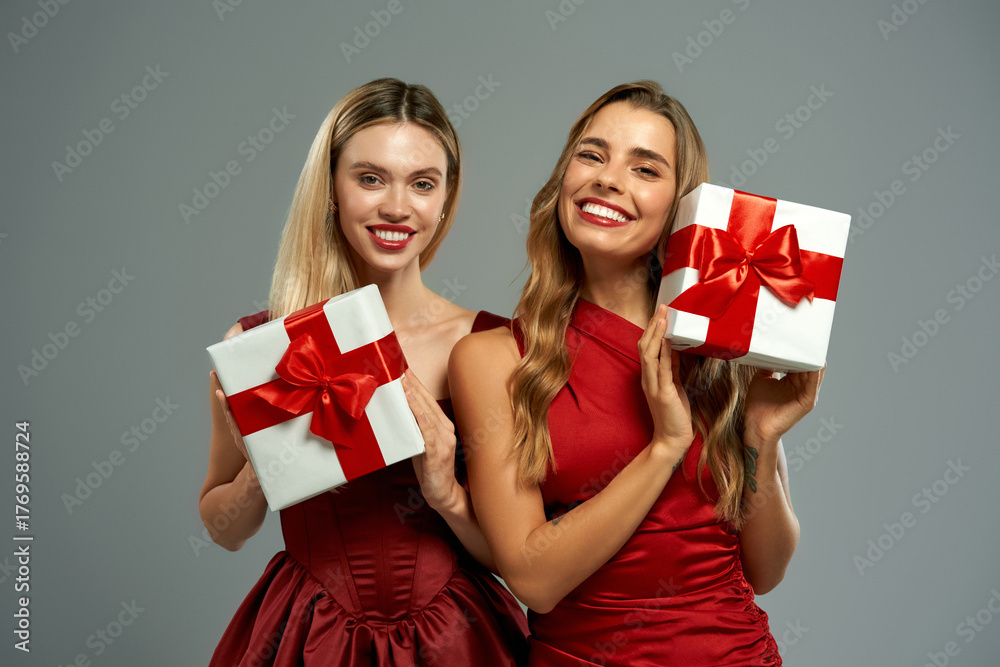 Fototapeta premium Women holding white gift boxes with red bows on gray background