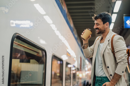 Φωτογραφία Happy man commuting by train enjoying coffee