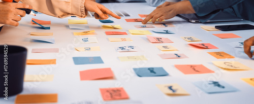 Tableau sur toile A vibrant scene of diverse hands reaching for colorful sticky notes on a white table, highlighting creative collaboration and brainstorming in a modern workspace setting