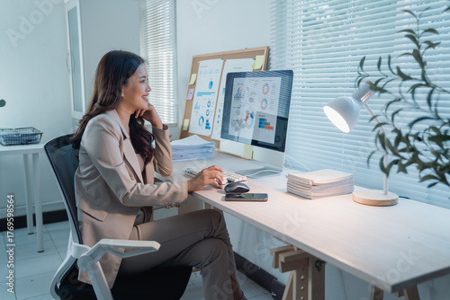Cuadro en lienzo Asian businesswoman working late in a modern office, analyzing business data and